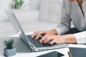 social médias journée concept. femelle pigiste départ travail journée de bonne heure dans Matin en buvant café dans vivant pièce pour site Internet avec en utilisant moderne portable ordinateur. femme d'affaires travail dans Accueil bureau. photo