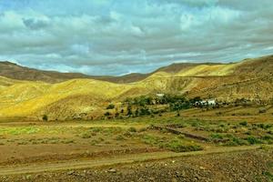 vide mystérieux montagneux paysage de le centre de le canari île Espagnol fuerteventura avec une nuageux ciel photo