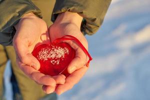 coeur en verre rouge dans les mains photo