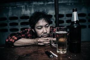 homme asiatique boit de la vodka seul à la maison la nuit Thaïlandais stress homme ivre concept photo