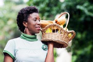 jeune femme tenant un panier de fruits à la main et aller pique-niquer photo