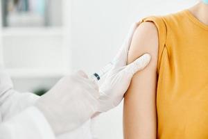 professionnel médecin détient le sien main sur le épaule de une femme vaccination photo