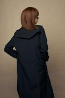 magnifique modèle manteau avec ceinture attrayant apparence posant sur un isolé Contexte photo