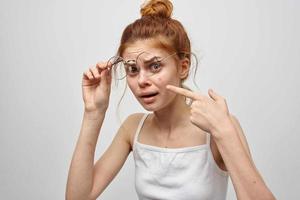 femme dans une blanc T-shirt avec des lunettes boutons sur sa visage photo