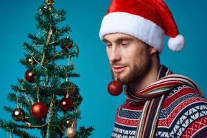 émotif homme dans une Père Noël chapeau Noël décorations vacances Nouveau année rouge Contexte photo