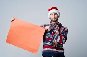 émotif homme dans Nouveau années vêtements en portant une bannière vacances lumière Contexte photo
