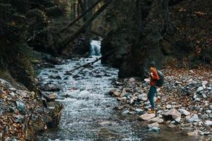 voyageur avec sac à dos paysage montagnes transparent rivière étang et forêt dans le Contexte photo