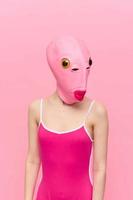 moderne Halloween costume dans une silicone masque dans le forme de une rose poisson tête dans une sexy costume. le concept de une fou Regardez photo