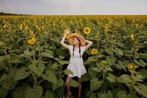 femme avec nattes dans une champ avec épanouissement tournesols paysage photo