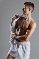 homme avec serviette dans blanc short athlète bodybuilder isolé Contexte photo