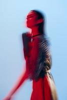 attrayant femme charme posant rouge lumière métal armure sur main mode de vie inchangé photo