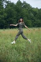 femme dans le Prairie sauter plus de le herbe vert combinaison Frais air photo