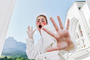 de bonne humeur femme dans une blanc peignoir sur une Contexte de montagnes Matin la nature photo