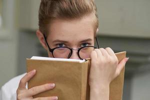 jolie femme avec une livre dans le sien mains en plein air en train de lire mode de vie photo