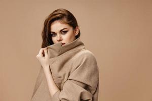 portrait femme dans beige manteau avec collier et coiffure modèle tondu vue photo