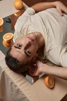 un attrayant homme mensonges sur un Orange table et un attrayant Regardez fermer photo