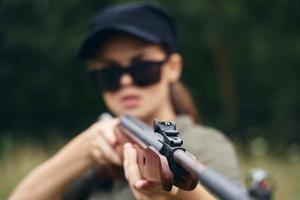 militaire femme longue pistolet vue objectif chasse noir casquette vert des arbres photo