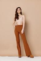 nu femme dans soutien-gorge et un pantalon bottes beige Contexte photo