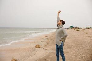 portrait de une femme seul par le océan nuageux temps content femelle relaxant photo