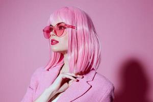 portrait de une Jeune femme dans rose des lunettes produits de beauté charme émotions Couleur Contexte inchangé photo