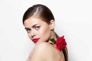 magnifique femme Rose fleur sur le épaules clair peau rouge lèvres photo