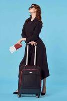 femme dans noir manteau bagage passeport avion des billets affaires voyage photo