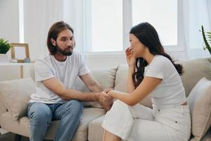 un asiatique femme est triste et pleurs avec sa Masculin ami à maison. stress et malentendu dans une relation entre deux gens photo