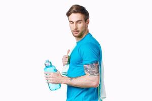 sportif homme avec serviette sur épaules faire des exercices l'eau bouteille tondu vue photo