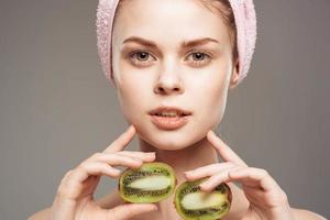 magnifique femme nu épaules spa traitements kiwi dans mains Naturel produits de beauté photo