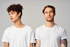 deux de bonne humeur copains dans t-shirts supporter côté par côté isolé Contexte joie photo