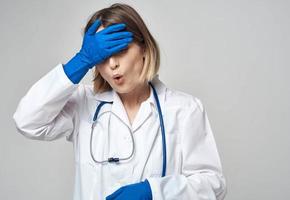 femme médecin dans une médical robe bleu gants stéthoscope travail une infirmière photo