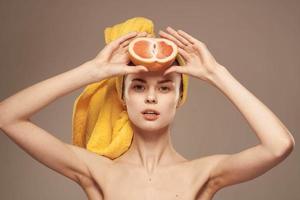 femme avec pamplemousse dans mains nu épaules et peau se soucier vitamines photo