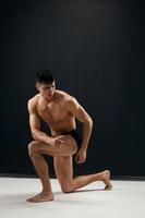 homme avec une gonflé à bloc corps dans foncé culotte studio modèle photo