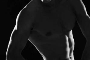 sportif musclé homme dans noir short bodybuilder foncé Contexte photo