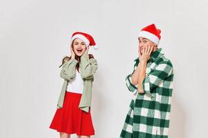 émotif homme et femme dans de fête Chapeaux toucher leur visage avec leur mains sur une lumière Contexte photo