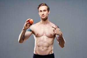 homme avec Pomme et sport en bonne santé nourriture pompé en haut gâteau bodybuilder photo