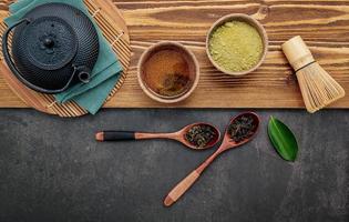 Théière en fonte noire avec tisane mis en place sur un fond de pierre sombre photo