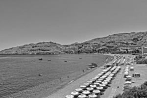 plage sur le grec île de Rhodes avec bleu l'eau et une bande sur une chaud l'été vacances journée photo