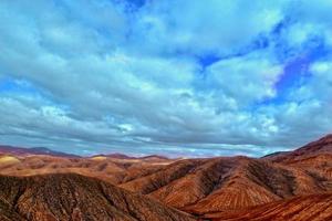 vide mystérieux montagneux paysage de le centre de le canari île Espagnol fuerteventura avec une nuageux ciel photo