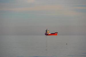 rouge cargaison navire dans le bleu mer calme minimaliste paysage photo