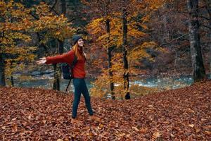 femme dans plein croissance en marchant dans le parc dans l'automne dans la nature près le rivière photo