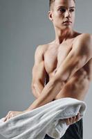 sportif homme avec pompé en haut corps posant avec les serviettes dans mains tondu vue de faire des exercices photo