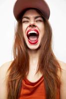 portrait de une femme dans une casquette amusement bouche large ouvert fermé yeux rouge lèvres photo