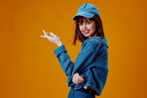 positif Jeune femme denim Vêtements mode posant casquette Couleur Contexte inchangé photo