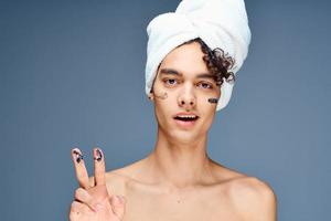 homme avec nu épaules serviette sur tête crème nettoyer peau cosmétologie photo