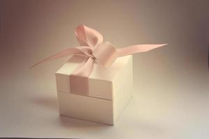 une cadeau dans une blanc boîte avec une rose arc photo