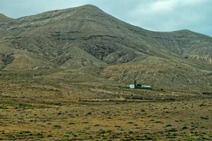 vide mystérieux montagneux paysage de le centre de le canari île Espagnol fuerteventura avec une nuageux ciel photo