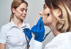 composition médecin dans une foule et dans bleu gants et une patient dans une blanc T-shirt sur une lumière Contexte photo