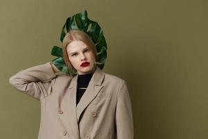 à la mode femme dans manteau rouge lèvres mode paume feuille isolé Contexte photo