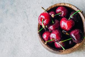 cerises mûres fraîches dans un bol en bois photo